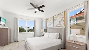 A modern bedroom with a large bed, a ceiling fan, a nightstand with a lamp, and a view of the outside. - Boutique Retreat, Azzure Resort, Near Orlando and Disney by Shine Villas (Davenport)