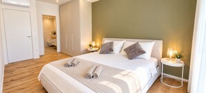 A hotel room with a bed, bedside tables, a wardrobe, and a bathroom visible through an open door.