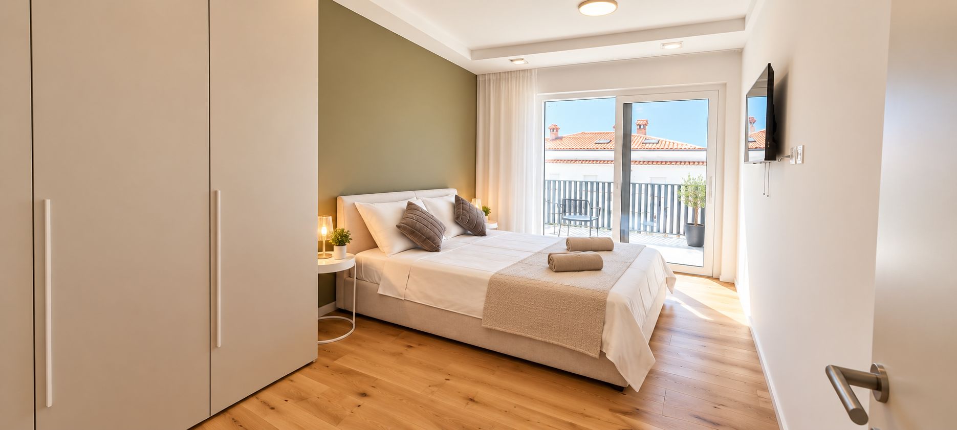Une chambre à coucher avec un lit, une table de chevet et une vue sur un balcon.