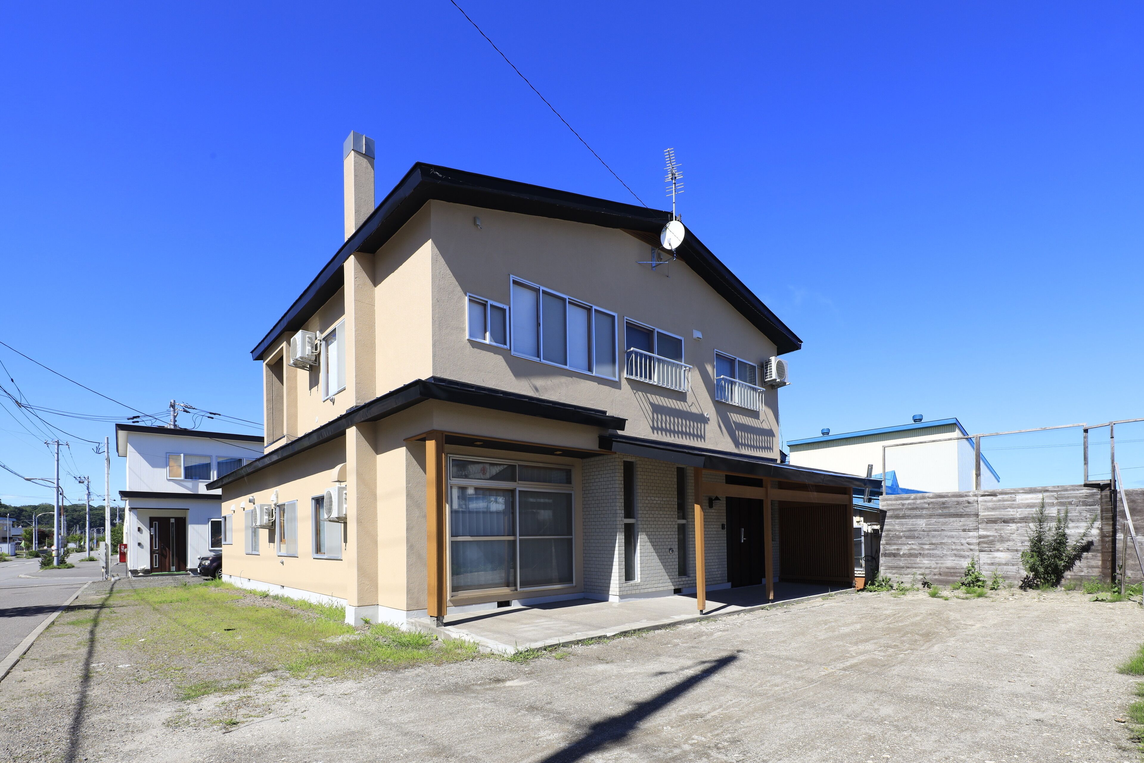 A two-story residential building with a garage, large windows, and a flat roof.