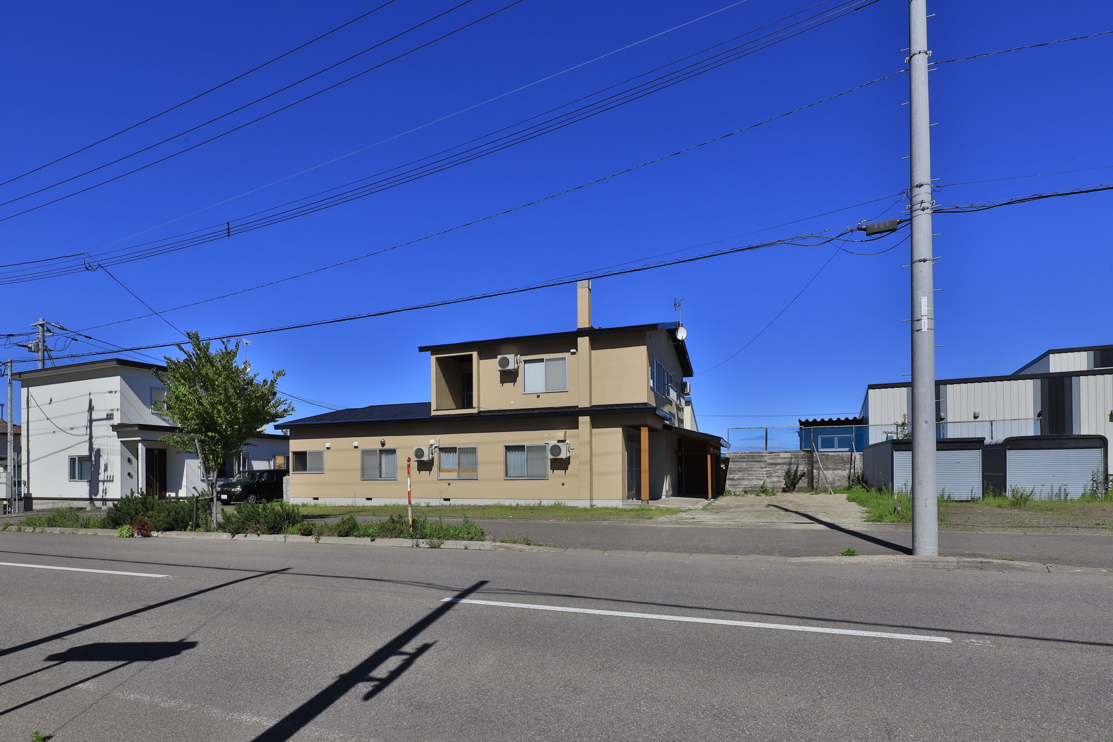 A two-story building with a flat roof and a small attached garage.