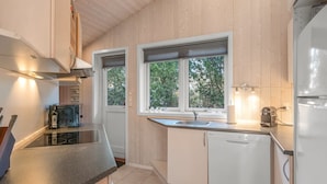 A modern kitchen with wooden walls, a dishwasher, a sink, and a stove. - "Nashota" - 600m from the sea by Interhome (Væggerløse)