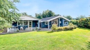 A two-story house with a covered porch and a fenced yard. - "Nashota" - 600m from the sea by Interhome (Væggerløse)