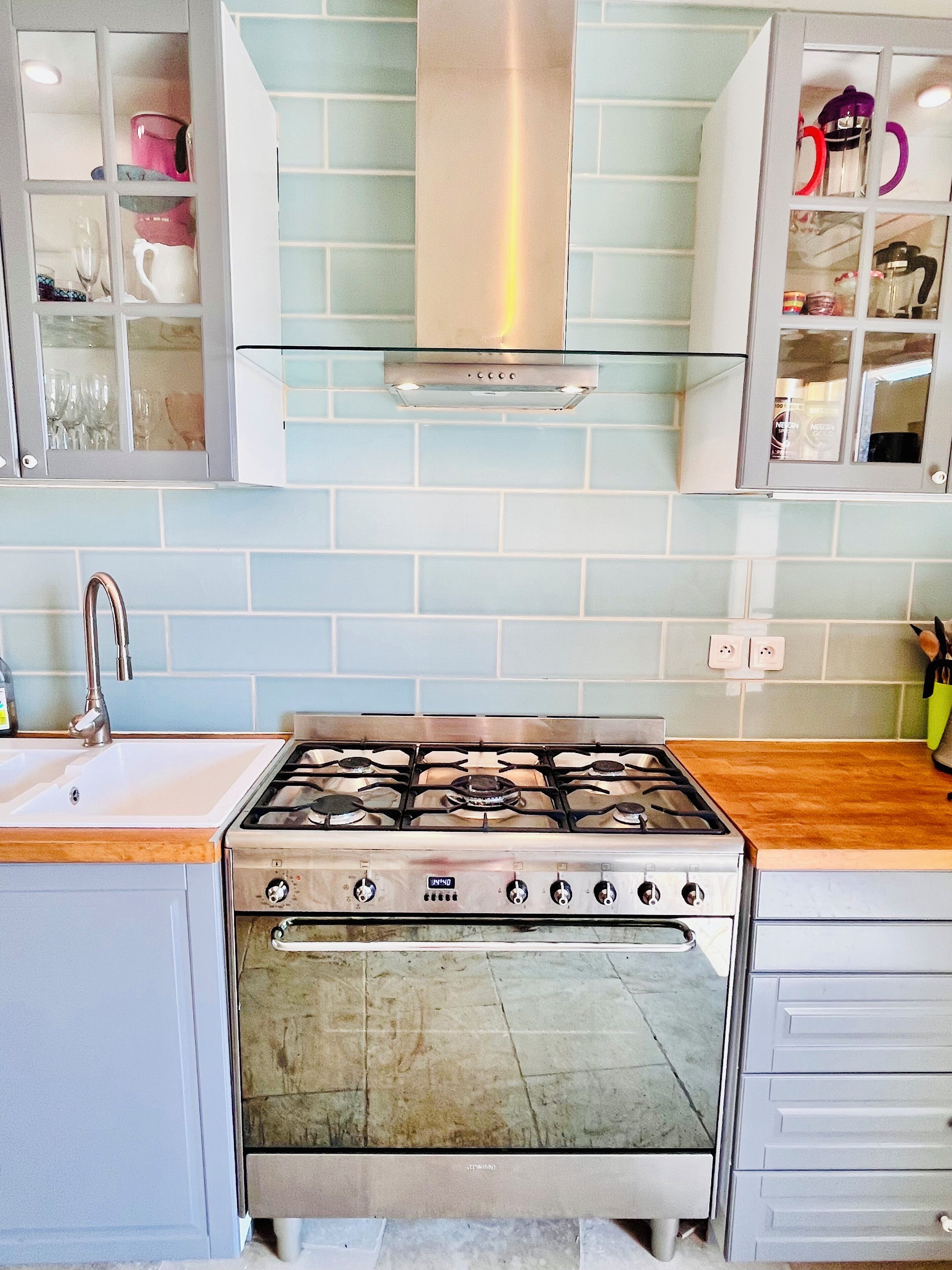 Une cuisine équipée d’une cuisinière à gaz, d’un évier et d’un four encastré.