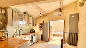 A kitchen with a wooden countertop, stainless steel appliances, and a view to an outdoor balcony.
