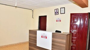 Un comptoir d’accueil avec une pancarte, une porte en bois et un certificat encadré accroché au mur.