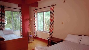 Una habitación con dos camas, un banco de madera, una mesita y una silla.