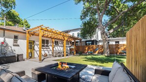 An outdoor patio with a fire pit, wicker furniture, and a pergola. - Backyard Wonderland: Ultimate Outdoor Fun (Denver)