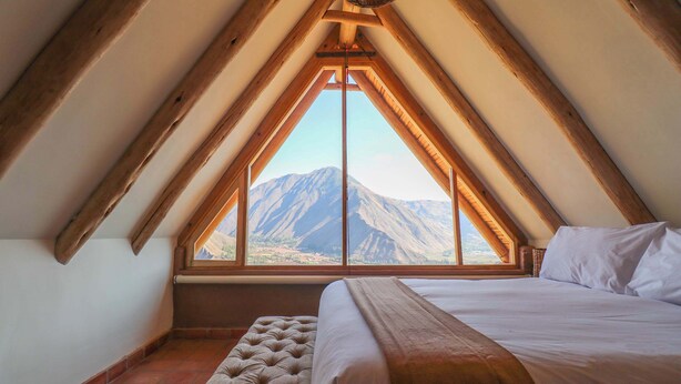 A bedroom with a large window, a bed, and a bench. - w* | Splendid 3BR House in Valle Sagrado (Urubamba)
