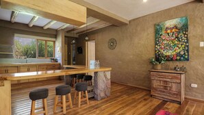Une cuisine moderne avec un bar en bois, des tabourets et un comptoir en pierre.