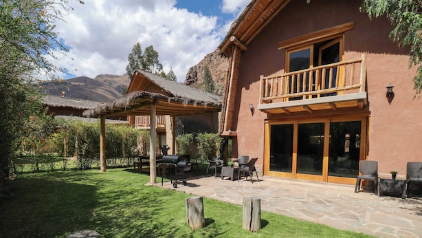 A house with a patio, outdoor seating, and a mountain backdrop.