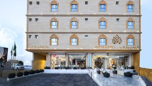 A multi-story hotel with a modern facade, multiple balconies, and a prominent entrance with a coffee shop sign. - Arjan Park Hotel Wadi Ad Dawasir (Wadi-Ad-Dawasir)