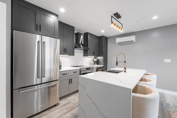 Brand new modern kitchen, featuring stainless steel appliances in a bright and open layout.