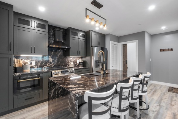 Brand new modern kitchen, featuring stainless steel appliances in a bright and open layout. The large island with seating for four makes this a great space for meals and entertaining.