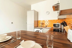 Kitchen equipped with microwave, toaster, and sink with faucet and soap dispenser.