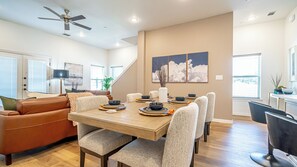 Un comedor moderno con una mesa de madera dispuesta para seis personas, rodeada de sillas tapizadas.