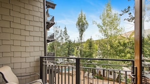 A balcony with a view of a swimming pool, outdoor furniture, and a brick wall. - Foxtail Flat | Capitol Peak Lodge #3219 | 1B/1B (Snowmass Village)