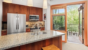 A modern kitchen with granite countertops, stainless steel appliances, and wooden cabinets. - Foxtail Flat | Capitol Peak Lodge #3219 | 1B/1B (Snowmass Village)