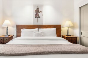 A hotel room with a wooden headboard, white bedding, two bedside tables with lamps, and a decorative wall piece above the bed. - Maroon Point | Capitol Peak Lodge #3516 | 1B/1B (Snowmass Village)