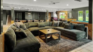 Ein modernes Wohnzimmer mit einem Ecksofa, einem Holztisch und einer Wand mit Steinverkleidung.