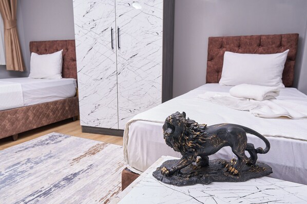 A bedroom with a marble wardrobe, a bed with a headboard, and a decorative lion sculpture. - Pequena Casa Apart (Istanbul)