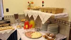 Una mesa de buffet con diversas opciones de comida, como frutas, pasteles y bebidas.