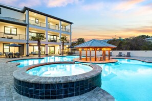 A multi-story hotel with a swimming pool, lounge chairs, and a gazebo. - Atlantis | Resort-Style Pool/Spa | Game Room | Steps to the Beach (Destin)