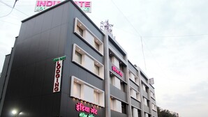 Een meerhoog hotel met borden waarop 'INDIA HOTEL' en 'INDIA GATE' staat.