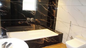 Een moderne badkamer met een ruime badkuip, een aparte douche en een wastafelmeubel met een wastafel.