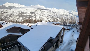 A snow-covered mountain landscape with buildings and a ski slope. - Cozy apartment near slopes, valley view (La Plagne Montchavin Les Coches)
