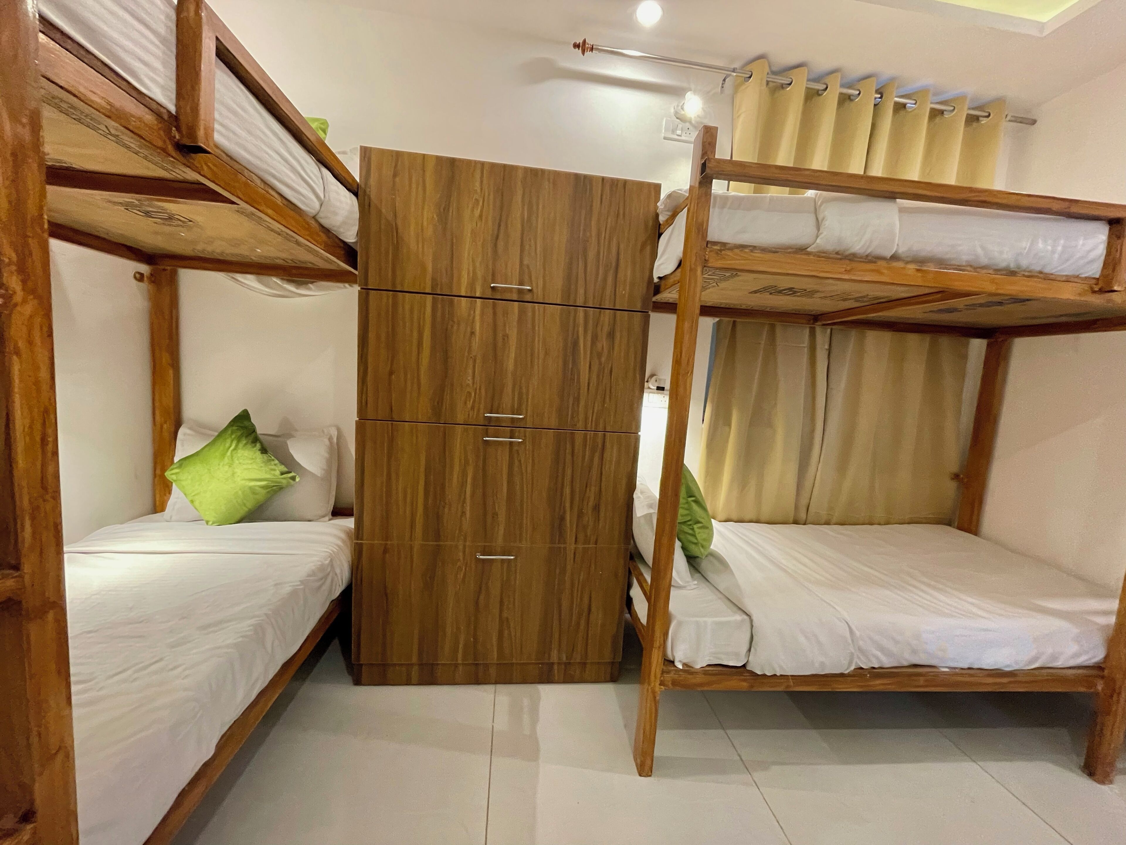 A bunk bed room with a wooden wardrobe and a ceiling light.