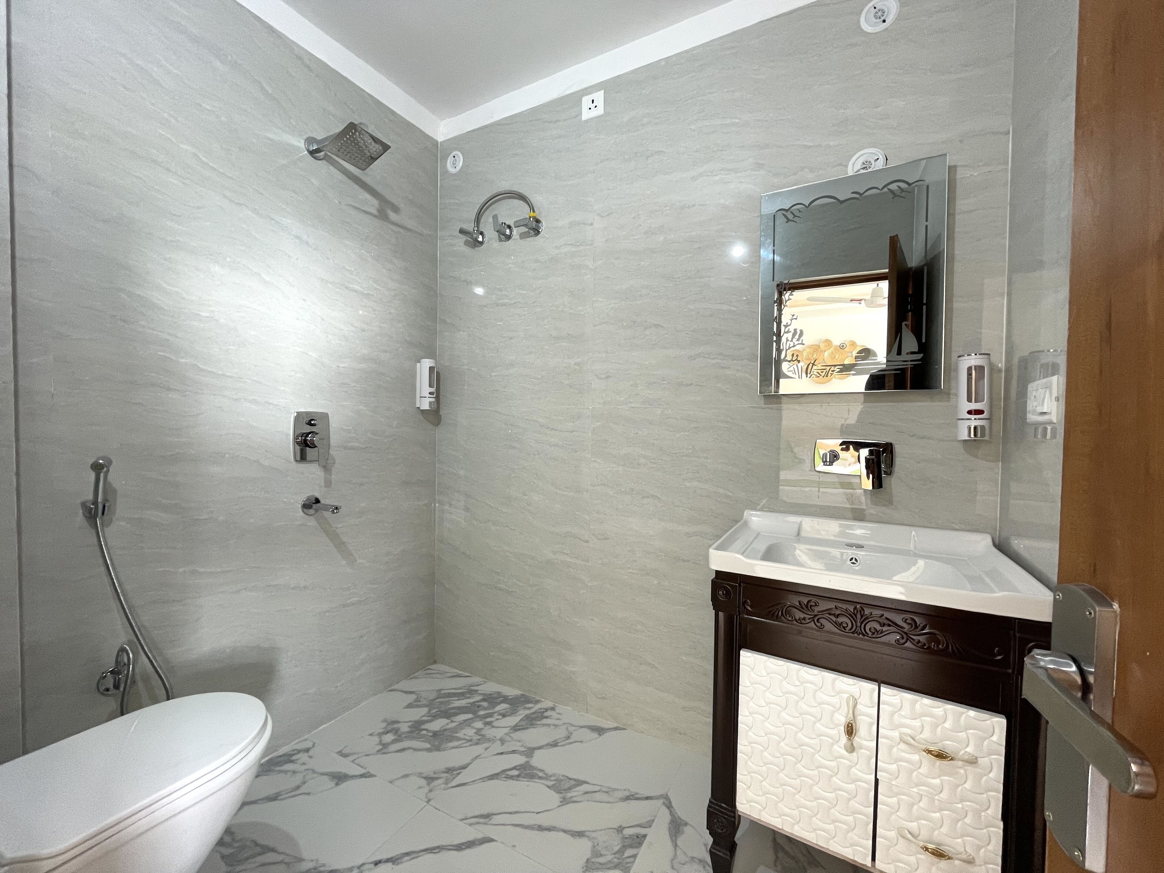 A bathroom with a toilet, a shower, a sink, and a cabinet.