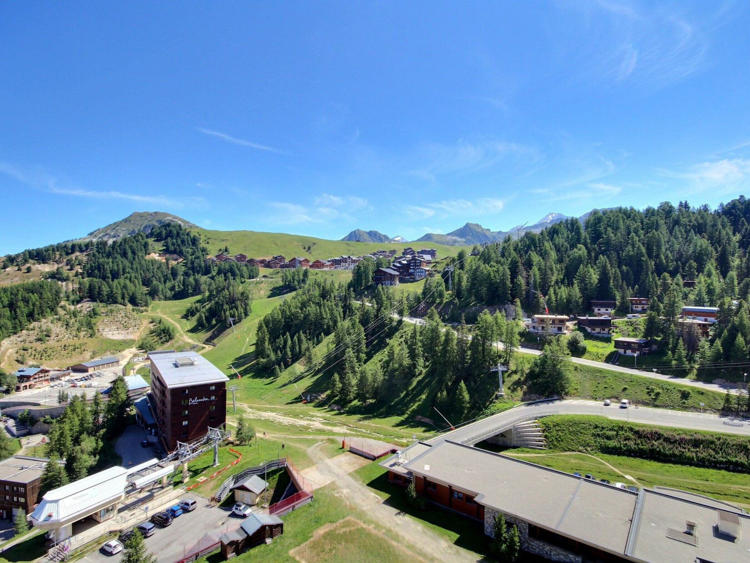 Un hotel dal design moderno, situato in zona montana con una stazione sciistica sullo sfondo.