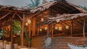 A rustic building with a thatched roof, wooden beams, and hanging lanterns. - Triton Dondra (Dondra)