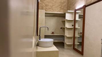 Une salle de bain avec un lavabo blanc, un meuble-lavabo en bois et un miroir.