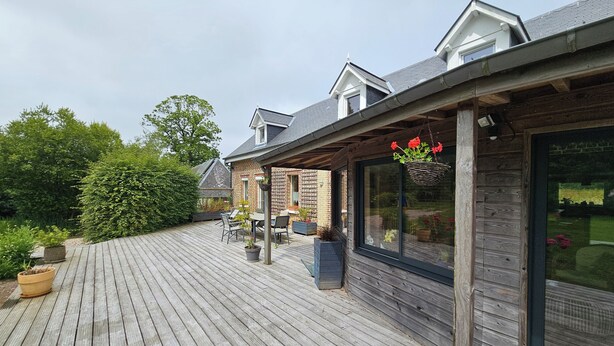 A wooden deck with outdoor furniture and potted plants.
