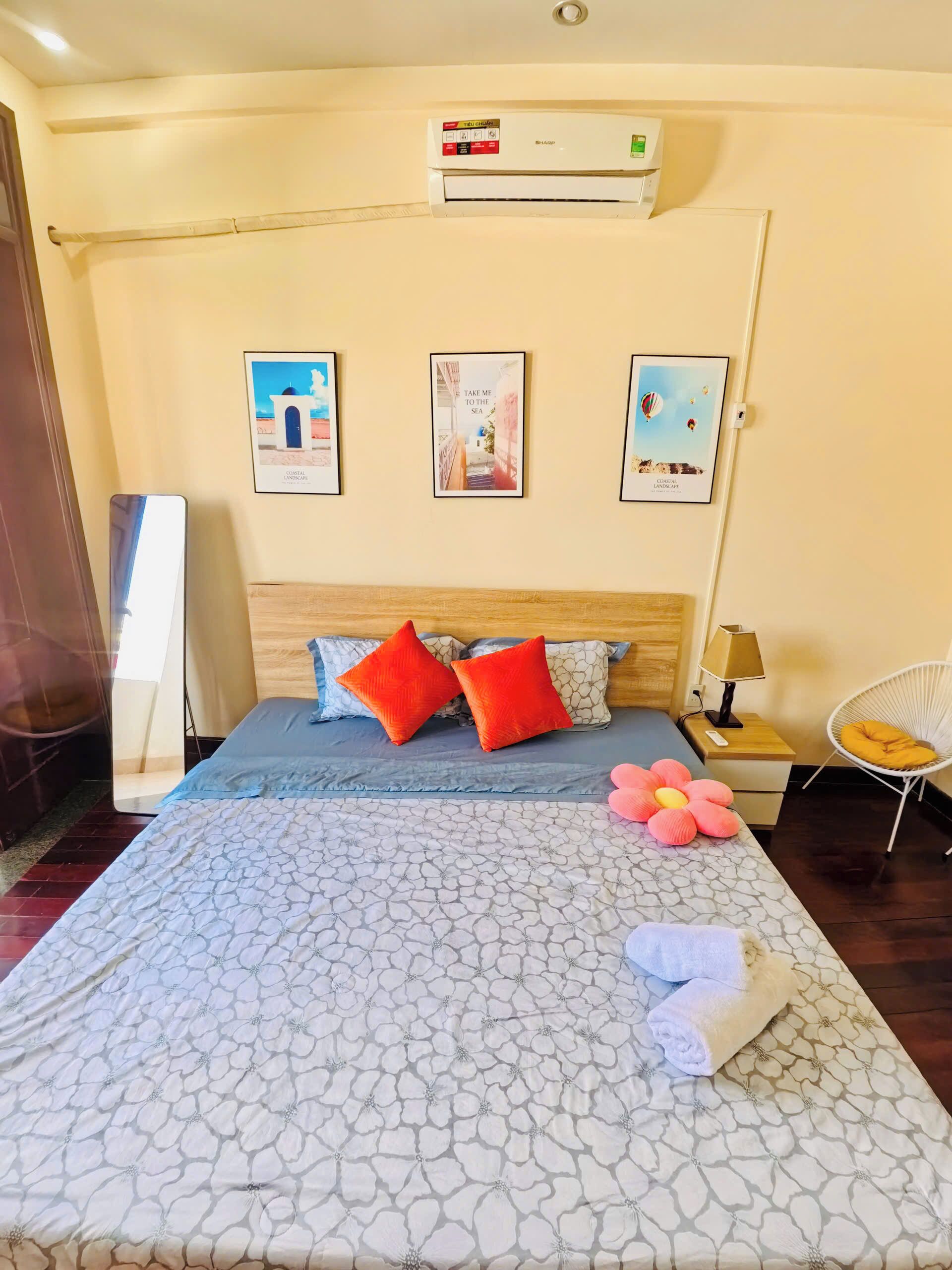 Une chambre d’hôtel avec un lit, une table de chevet, une chaise et des œuvres d’art murales.