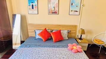 Une chambre d’hôtel avec un lit, une table de chevet, une chaise et des œuvres d’art murales.