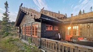 A rustic wooden cabin with a balcony, large windows, and a chimney. - Beautiful home in Rjukan with sauna (Rjukan)
