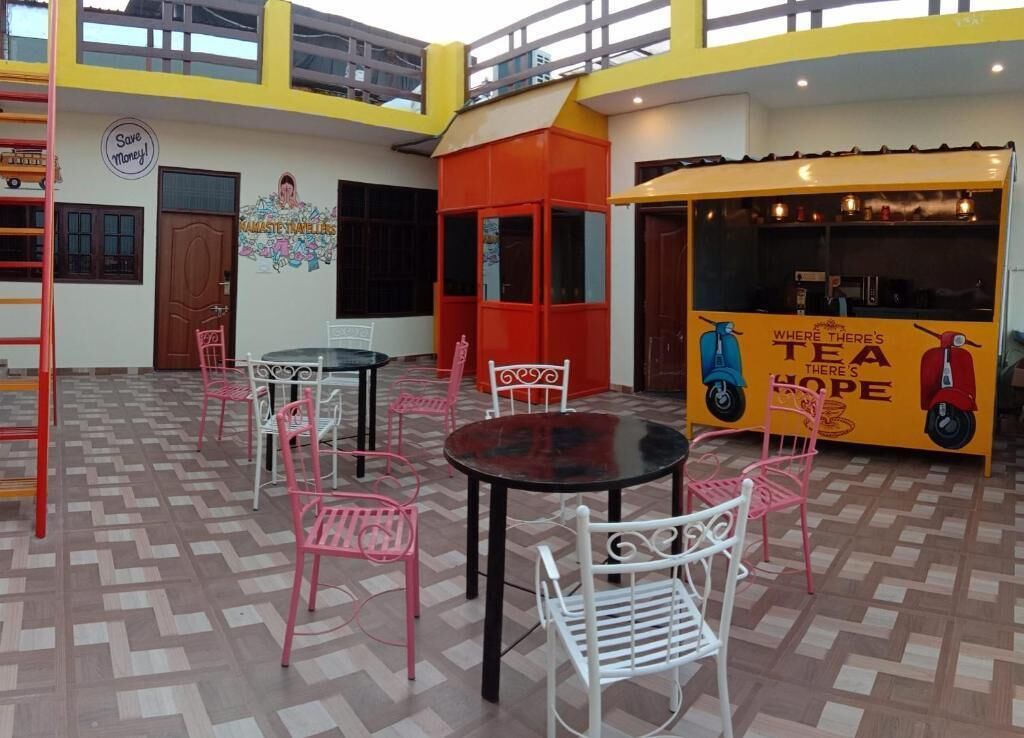 A café with tables and chairs, a mural, and a sign that says "Where There's Tea There's Hope".