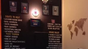 Un mostrador de recepción con encimera de madera y un peluche de panda. Sobre el mostrador, hay carteles con lugares para visitar, opciones gastronómicas turísticas y normas de la casa.