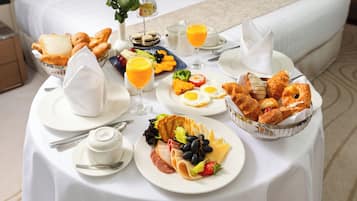 Een ontbijtbuffet met verschillende soorten eten en drinken op een tafel in een hotelkamer.