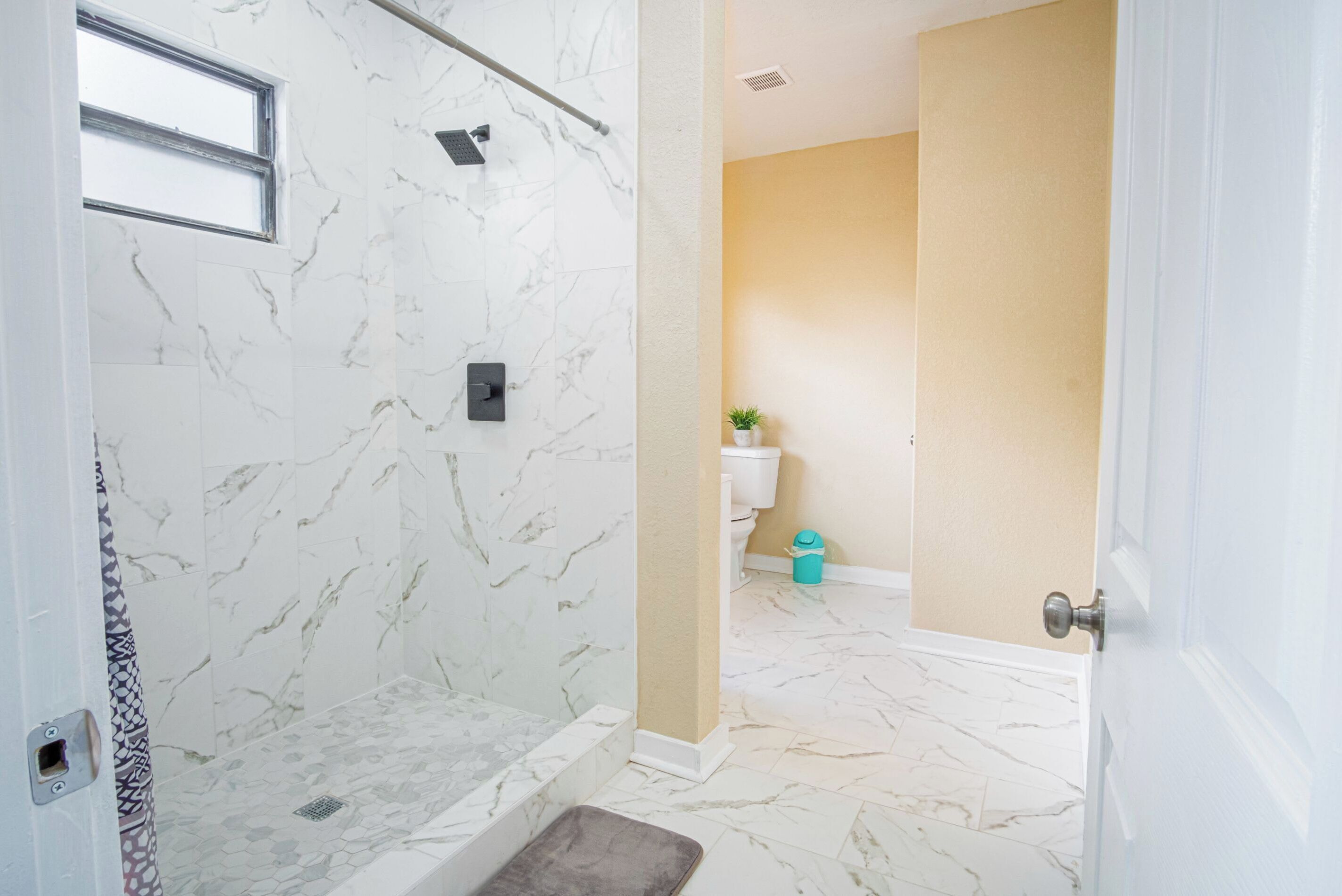 A bathroom with a shower, toilet, and sink.