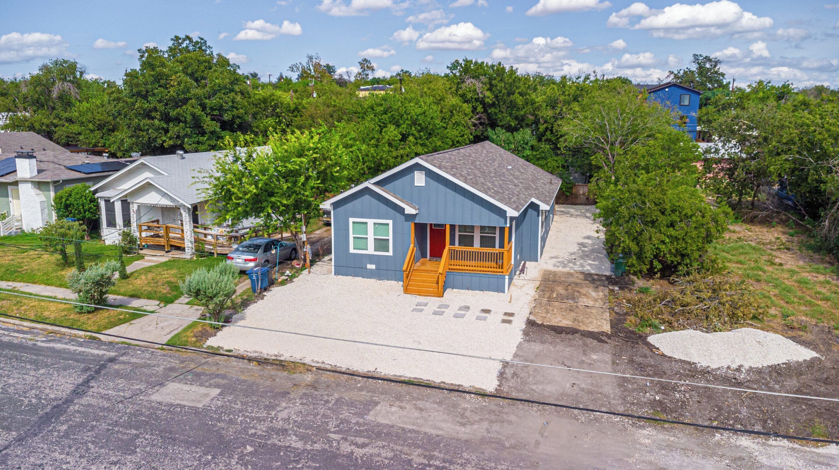 A residential house with a front porch, a driveway, and a garage.