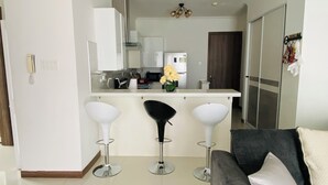 A modern kitchen with white cabinets, a central island, and two bar stools. - Island vibes Oasis with a beautiful Pool (Kingston)