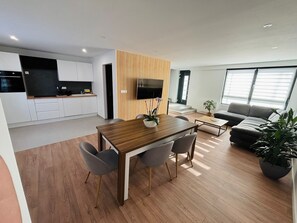 A modern apartment with a kitchen, dining area, and living room.