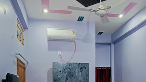 Ein Schlafzimmer mit Bett, Kleiderschrank, Deckenventilator, Klimaanlage und Fernseher.
