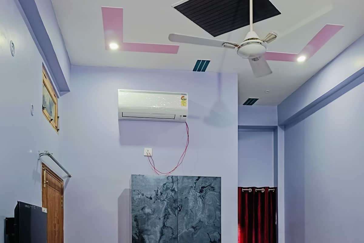 Una camera da letto con un letto, un armadio, una ventola a soffitto, l'aria condizionata e una televisione.