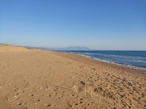 A wide sandy beach with footprints and a few wooden stakes. - 110 m² House in Kakovatos - Peloponnese (zacharo)