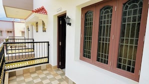 A clean, well-maintained interior with a tiled floor, a staircase with a railing, and a door leading to another room. - SSS Golden Resorts (Tarangambadi)